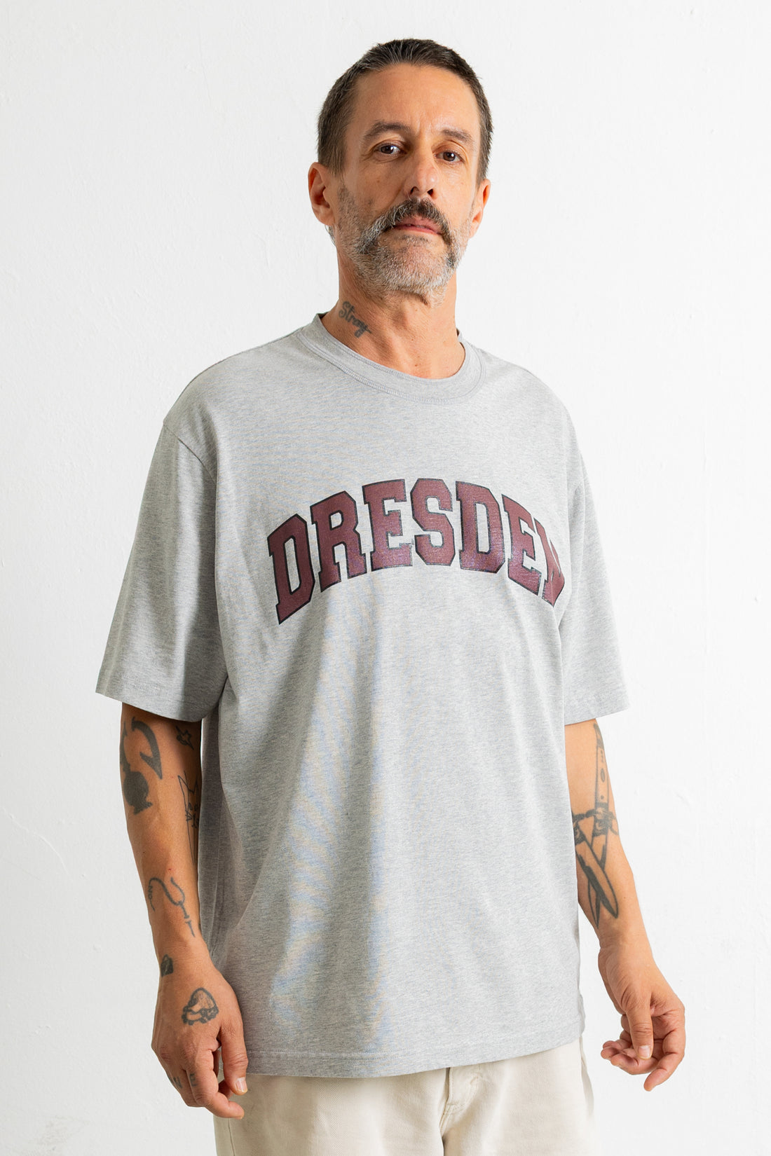 A man wearing a light grey heather crewneck t-shirt with &